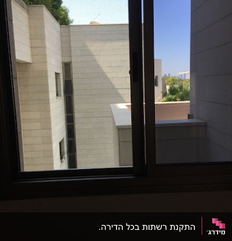 חלון אלומיניום פתוח עם נוף לבניינים חיצוניים